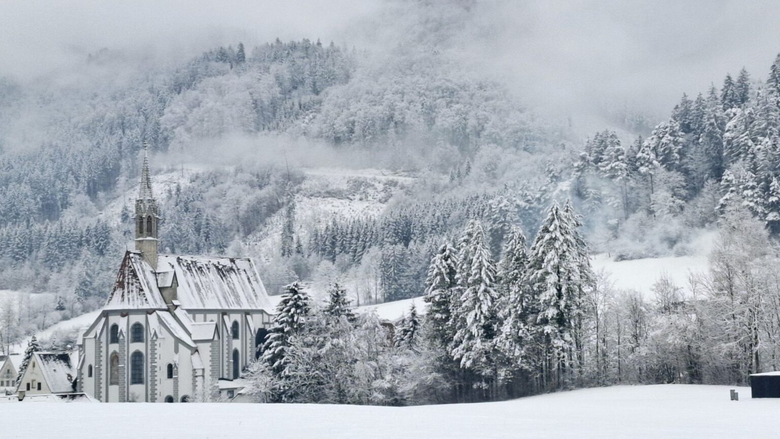 Skifahren am Ötscher, Unterkunft im Tal: die Kartause Gaming im Winter mit verschneiter Kirche und Wald